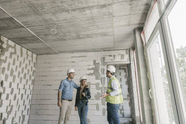 Architect talking with future owners on construction site - AHSF00817