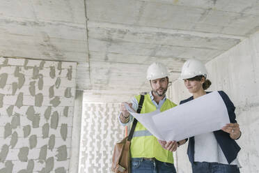 Architektin und weiblicher Manager im Gespräch über Architekturplan auf der Baustelle - AHSF00822