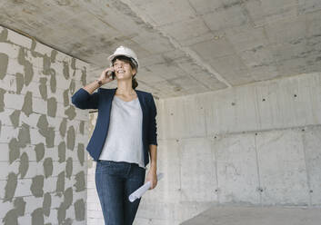 Architektin telefoniert auf der Baustelle - AHSF00847