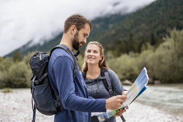 Young couple on a hiking trip reading map, Vorderriss, Bavaria, Germany - DIGF08254