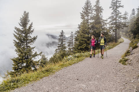 Junges Paar bei einer Wanderung in den Bergen, Herzogstand, Bayern, Deutschland, lizenzfreies Stockfoto
