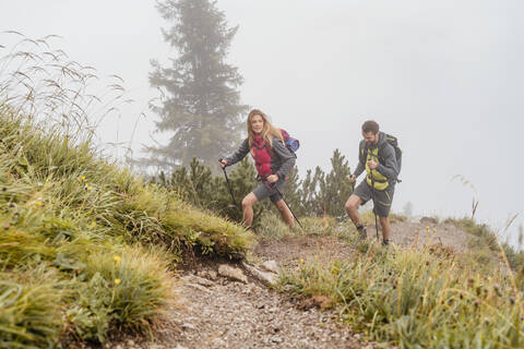 Young couple on a hiking trip in the mountains, Herzogstand, Bavaria, Germany stock photo