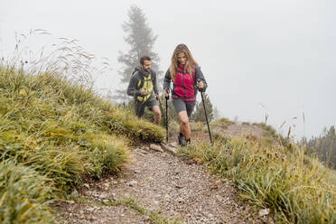 Young couple on a hiking trip in the mountains, Herzogstand, Bavaria, Germany - DIGF08266