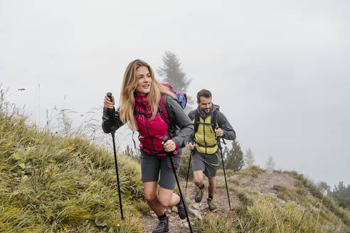 Young couple on a hiking trip in the mountains, Herzogstand, Bavaria, Germany - DIGF08267