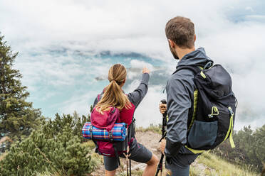 Junges Paar bei einer Wanderung in den Bergen mit Blick auf die Aussicht, Herzogstand, Bayern, Deutschland - DIGF08269