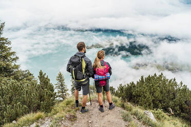 Junges Paar bei einer Wanderung in den Bergen mit Blick auf die Aussicht, Herzogstand, Bayern, Deutschland - DIGF08270