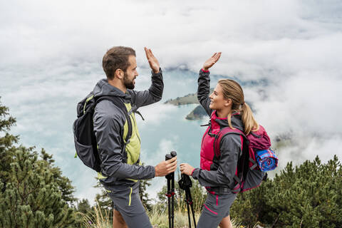 Glückliches junges Paar bei einer Wanderung in den Bergen, Herzogstand, Bayern, Deutschland, lizenzfreies Stockfoto