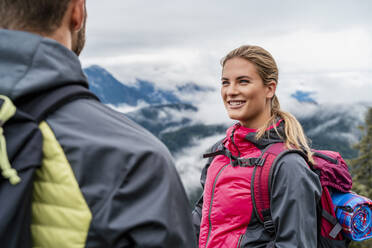 Smiling young couple on a hiking trip in the mountains, Herzogstand, Bavaria, Germany - DIGF08277