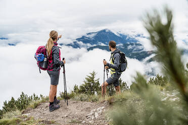 Junges Paar bei einer Wanderung in den Bergen mit Blick auf die Aussicht, Herzogstand, Bayern, Deutschland - DIGF08280