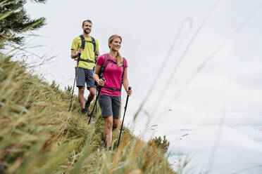 Selbstbewusstes junges Paar bei einer Wanderung in den Bergen, Herzogstand, Bayern, Deutschland - DIGF08282