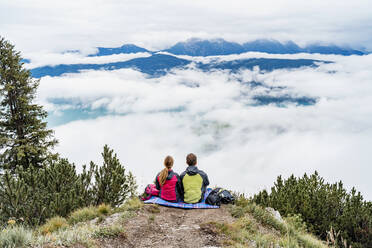 Young couple on a hiking trip in the mountains having a break, Herzogstand, Bavaria, Germany - DIGF08298