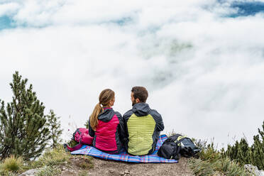 Young couple on a hiking trip in the mountains having a break, Herzogstand, Bavaria, Germany - DIGF08299
