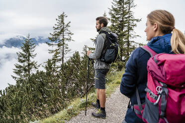 Junges Paar bei einer Wanderung in den Bergen mit Blick auf die Aussicht, Herzogstand, Bayern, Deutschland - DIGF08320