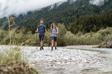 Young couple on a hiking trip at riverside, Vorderriss, Bavaria, Germany - DIGF08336