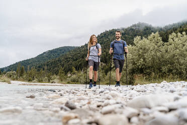 Junges Paar bei einer Wanderung am Flussufer, Vorderriss, Bayern, Deutschland - DIGF08337