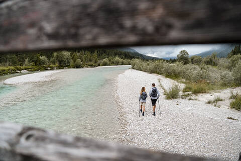 Junges Paar auf einem Wanderausflug am Flussufer, Vorderriss, Bayern, Deutschland, lizenzfreies Stockfoto