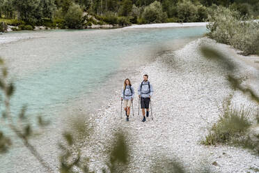 Young couple on a hiking trip walking at the riverside, Vorderriss, Bavaria, Germany - DIGF08373