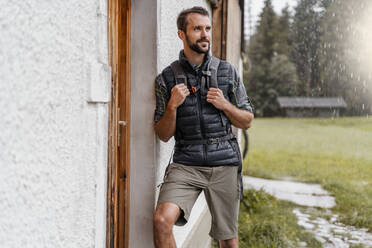 Junger Mann auf einem Bauernhof während einer Wanderung, Vorderriss, Bayern, Deutschland - DIGF08379