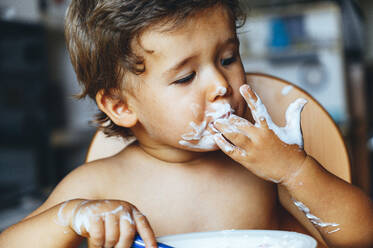 Little boy eating yogurt at home - JCMF00183