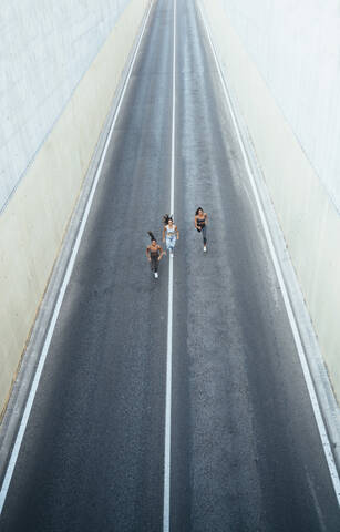 Top view of three sporty young women running on a street stock photo