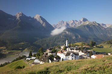 Green meadows frame the the alpine village of Ftan, Inn district, Canton of Graubunden, Engadine, Switzerland, Europe - RHPLF08799