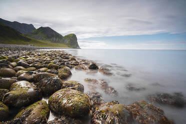 Felsen am Strand umrahmen das ruhige, klare Meer, Unstad, Vestvagoy, Lofoten, Norwegen, Skandinavien, Europa - RHPLF08808