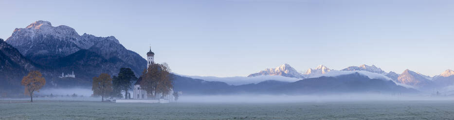 Panorama of St. Coloman Church surrounded by the autumn fog at sunrise, Schwangau, Bavaria, Germany, Europe - RHPLF08837