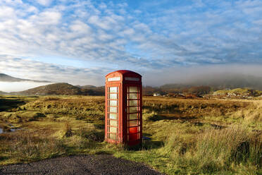 Herbstansicht einer roten Telefonzelle am Rande einer ruhigen Straße in den abgelegenen nebligen Ardnamurchan-Mooren der schottischen Highlands, Schottland, Vereinigtes Königreich, Europa - RHPLF08912