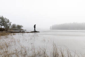 Man on rocks in frozen lake in Lotorp, Sweden - FOLF10933