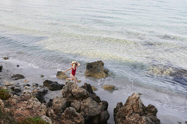 Junge Frau läuft am Strand - IGGF01306