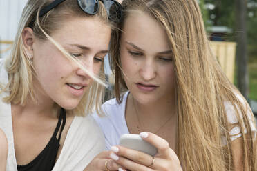 Two young women looking at cell phone - FOLF10996