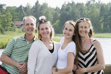 Familie mit erwachsenem Nachwuchs vor einem See - FOLF10998