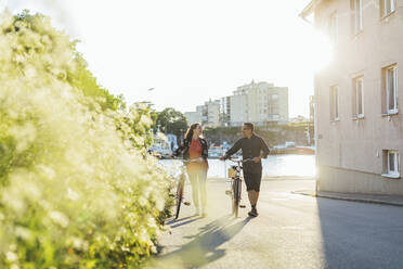 Couple with bicycles on suburban street - FOLF11075