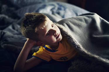 Boy lying under blanket on bed - FOLF11088