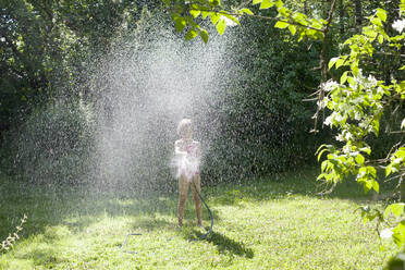 Girl playing with hose in backyard - FOLF11173