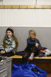 Mädchen in der Umkleidekabine bereiten sich auf das Eishockeytraining vor - FOLF11179