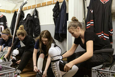 Mädchen in der Umkleidekabine bereiten sich auf das Eishockeytraining vor - FOLF11183