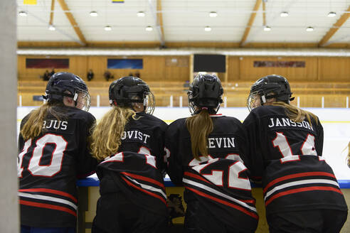 Mädchen in Eishockeyuniformen neben der Eislaufbahn - FOLF11185