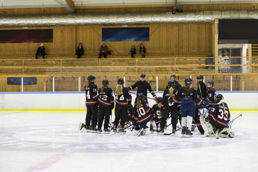 Mädchen hören ihrem Trainer beim Eishockeytraining zu - FOLF11186