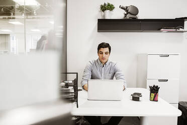 Young man using laptop at desk - FOLF11277