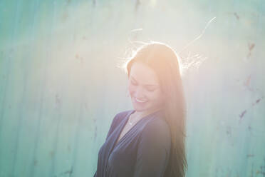 Young woman smiling in sunlight - FOLF11311