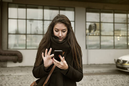 Junge Frau benutzt ein Smartphone - FOLF11390