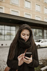 Junge Frau benutzt ein Smartphone - FOLF11391
