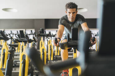 Portrait of man in spinning class in gym - DLTSF00086