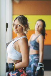 Portrait of two women with boxing gloves in gym - DLTSF00099