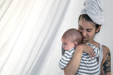 Tätowierte junge Frau hält ihr Baby - RIBF01003