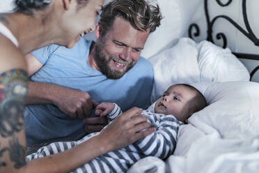 Happy parents with their baby in bed - RIBF01006
