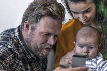 Familie mit Baby beim Telefonieren - RIBF01044