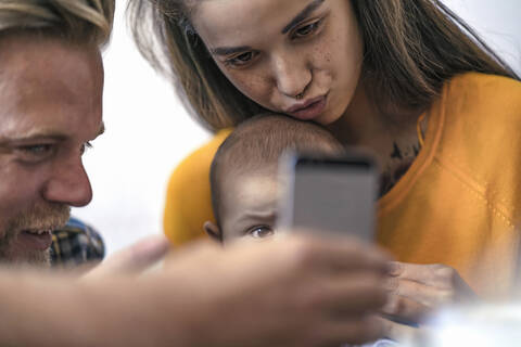 Family with baby using cell phone stock photo