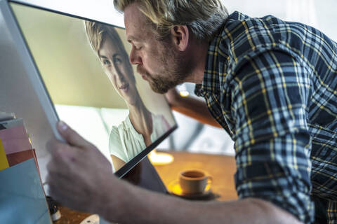 Mann küsst Frau auf Computerbildschirm, lizenzfreies Stockfoto